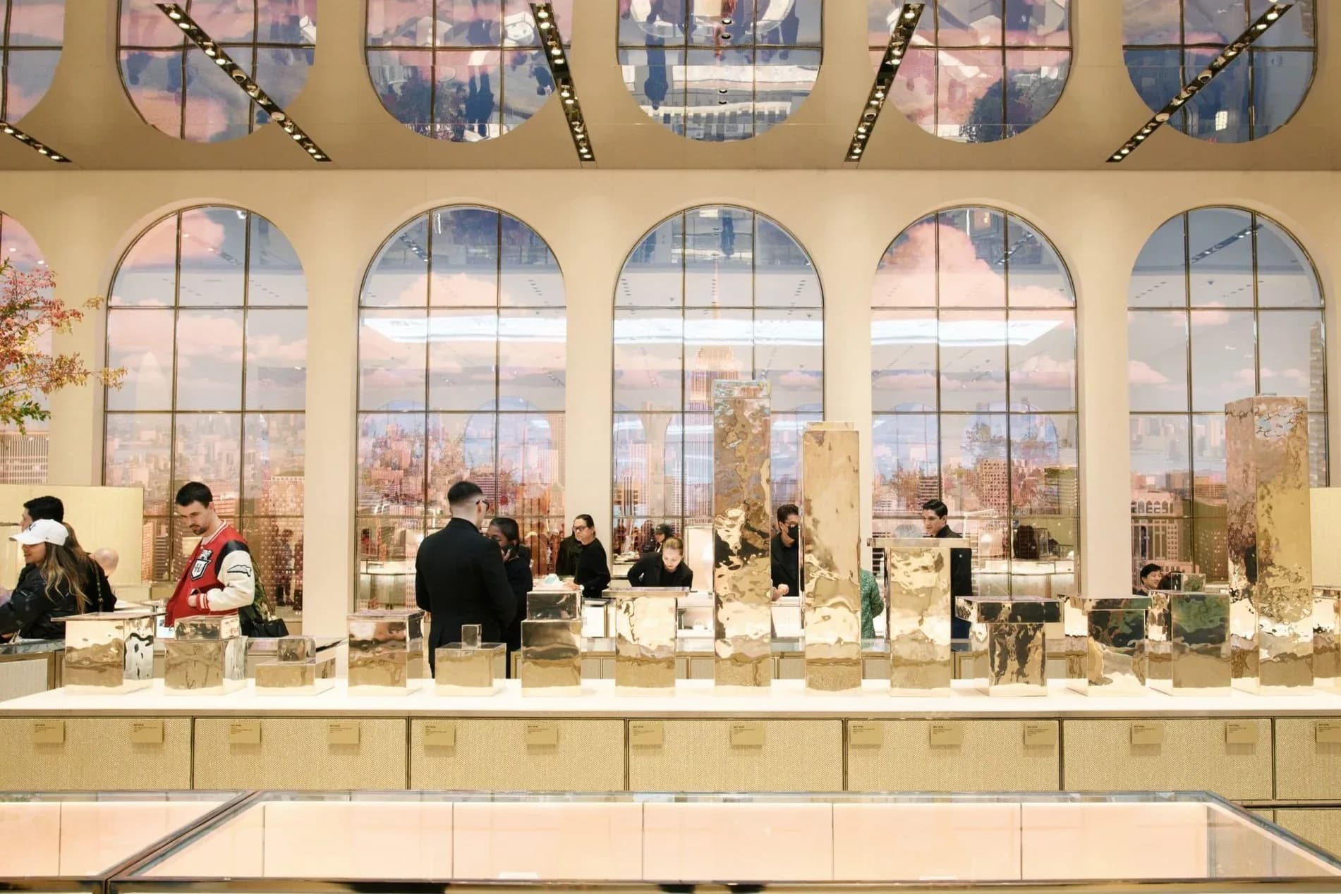 Modern retail counter with expansive arched windows overlooking cityscape, neutral palette, and minimalist display setup by Tillotson Design Associates.
