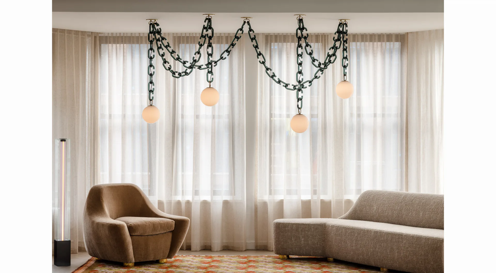 Luxurious living room with curved taupe furniture, draped garland lighting installation, and sheer curtains by Trueing.