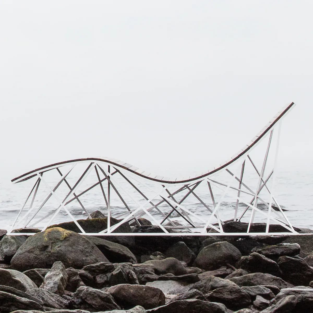 Wire-frame sculptural installation with organic curved forms elevated on rocky terrain, rendered in gray tones by Uhuru Design.