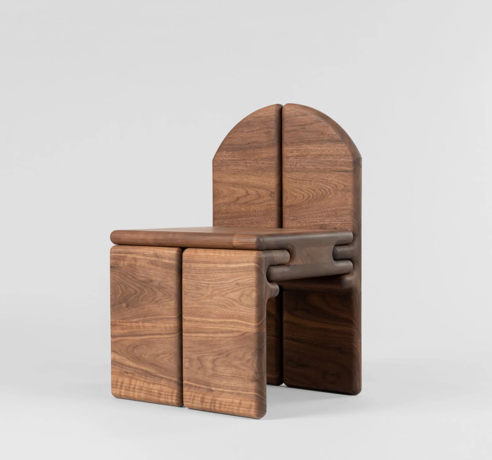 Wooden modular furniture pieces with curved tops and geometric interlocking joints in warm walnut tones, designed by Vonnegut/Kraft.