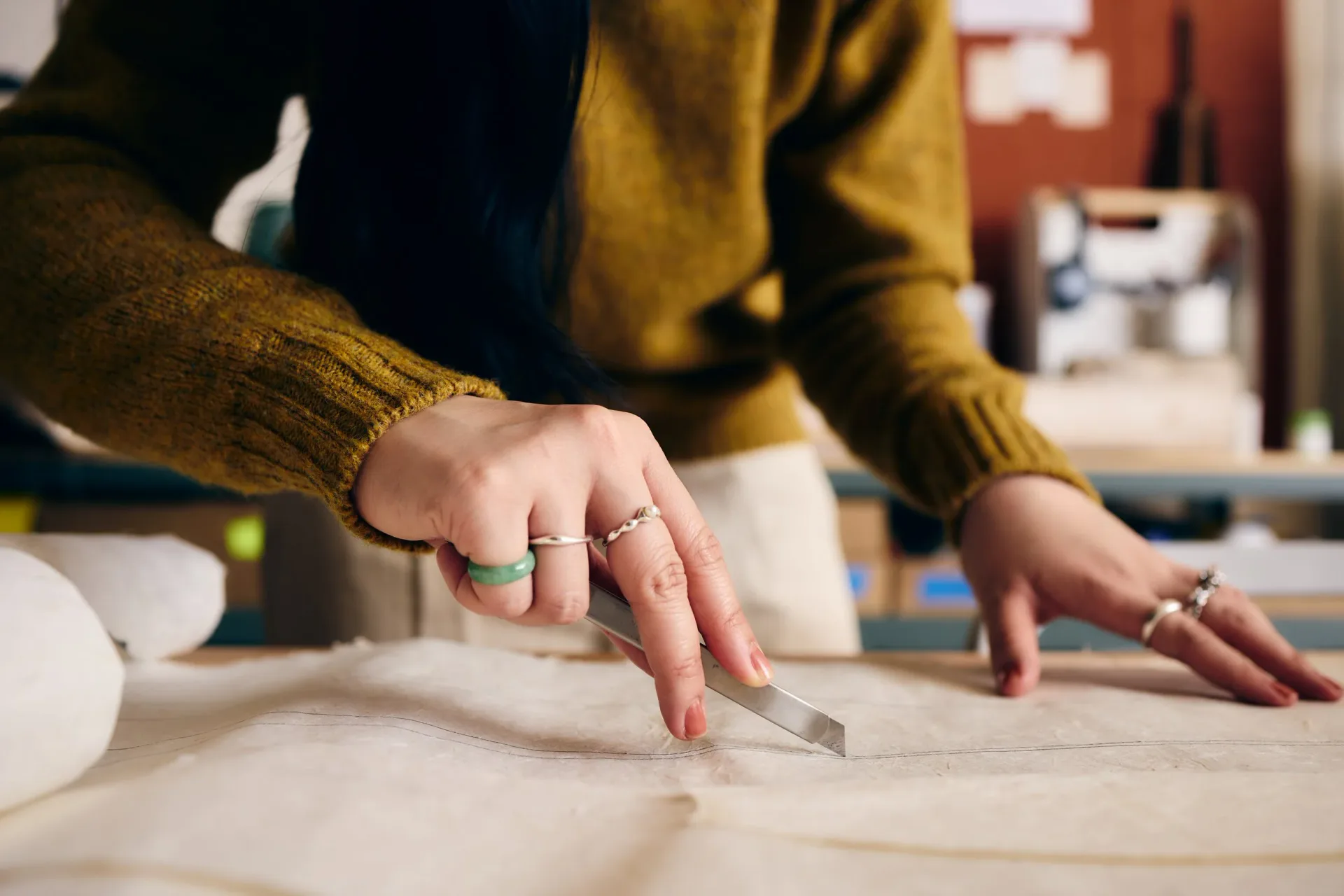 Designer's hands working on architectural blueprints and plans at a workspace, demonstrating design process and drafting work by Vy Voi.
