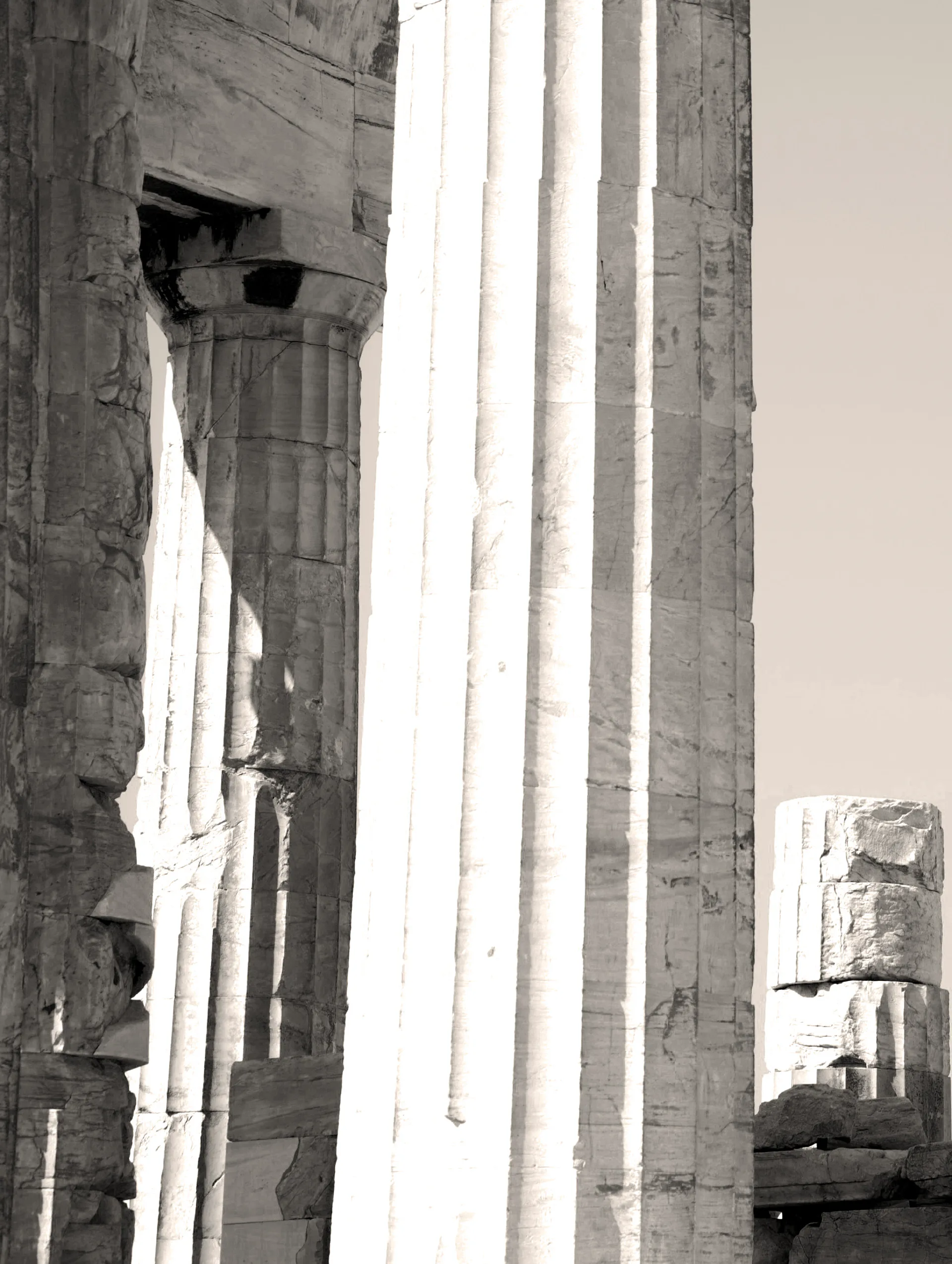 Classical stone columns with fluted details and weathered capitals, shot from below against bright sky, architectural documentation by Wartel.