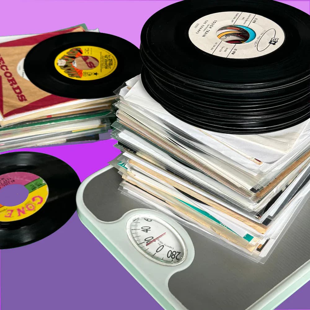 Styled flat lay of vinyl records and sleeves arranged on a scale against a vibrant purple background by WAXRAX.