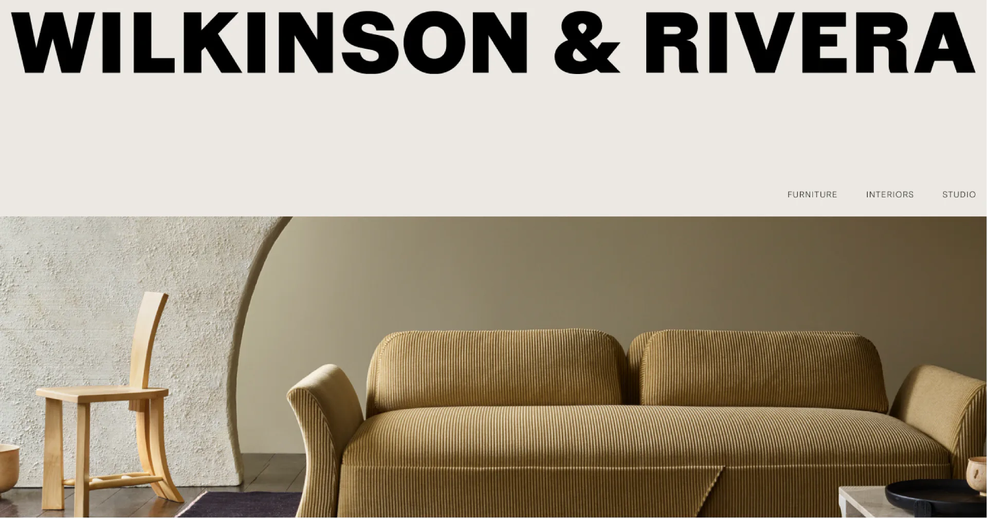 Modern living room interior featuring a ribbed mustard-yellow sofa, curved wall element, and warm neutral palette by Wilkinson & Rivera.