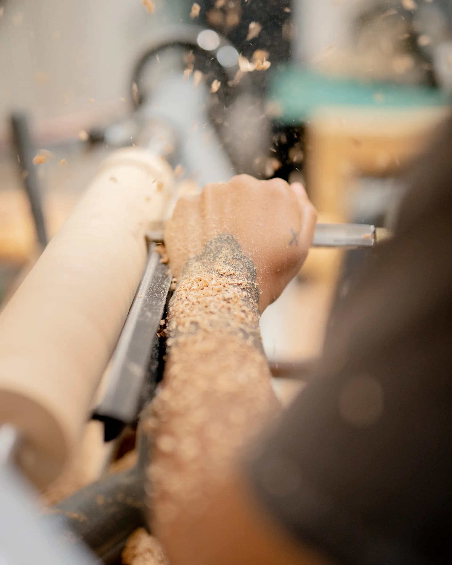 Close-up of woodworking detail showing planed wood shavings and precision tool work by Wilkinson & Rivera.
