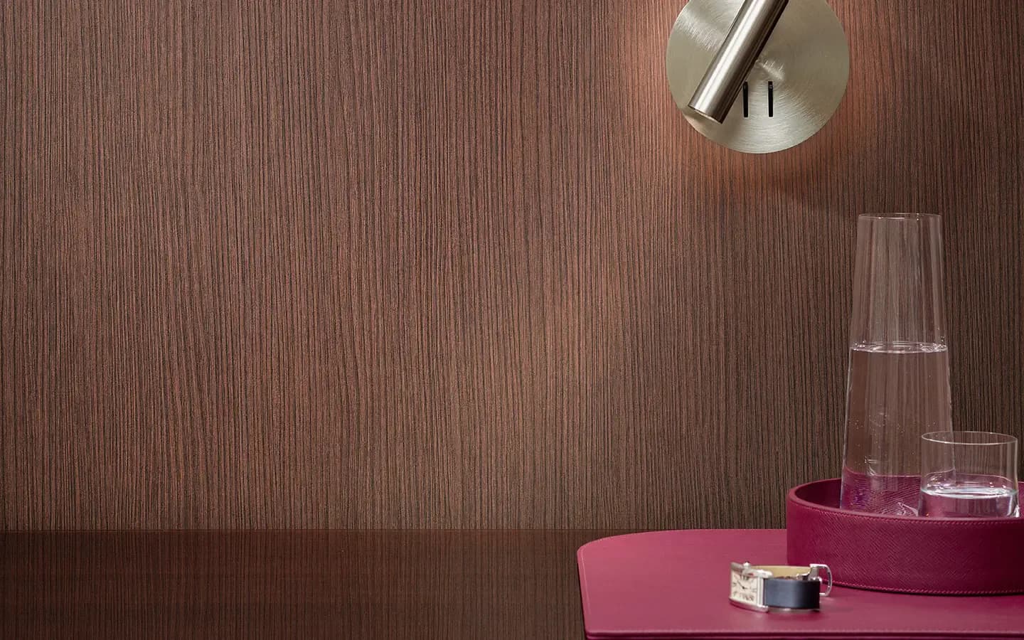 Modern bathroom or powder room interior featuring warm wood-grain wallcovering, pink vanity accessories, and minimalist chrome fixtures by Wolf-Gordon.