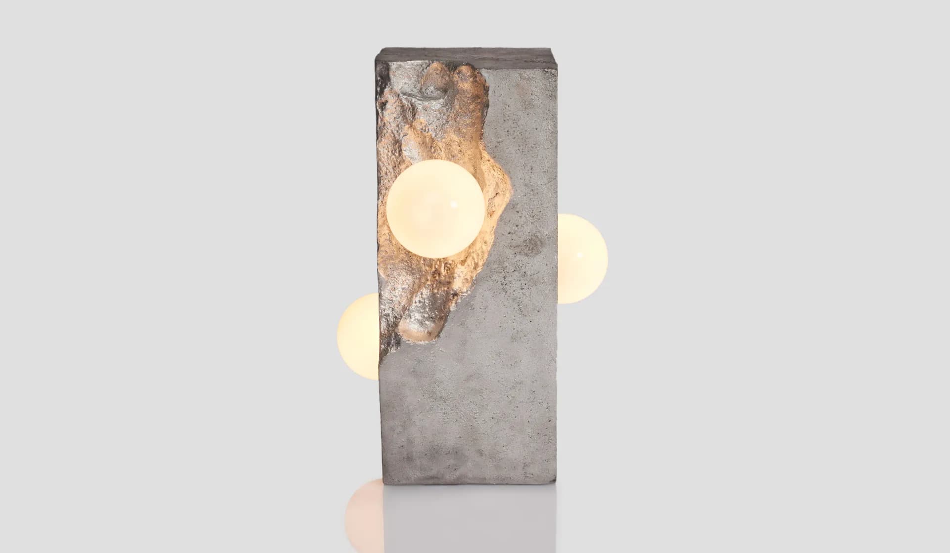 Minimalist concrete wall installation with illuminated spherical elements creating warm light accents, by Yasanche.