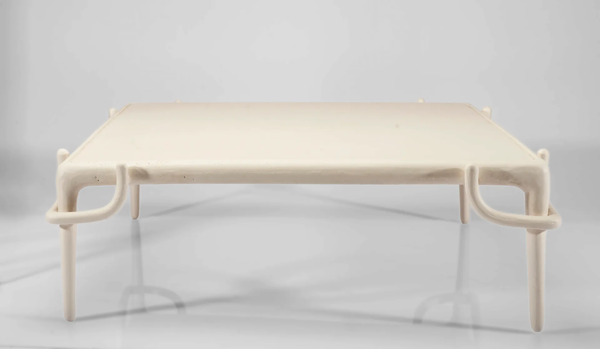 Minimalist cream-colored bench with curved armrests and wooden legs, shown in a clean studio setting by Yasanche.