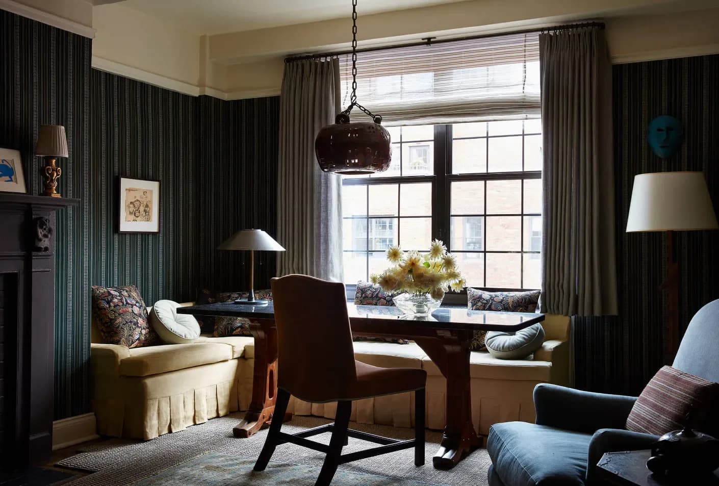 Sophisticated living room with dark vertical paneling, cream upholstered seating, wood furnishings, and layered drapery by Zak + Fox.